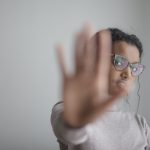 ethnic woman doing stop gesture with palm at camera