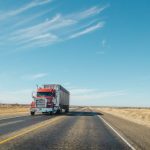 red and white truck on road under blue sky